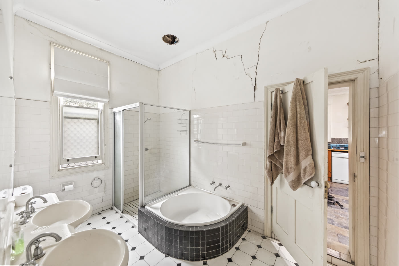Dated bathroom with cracked walls before renovation